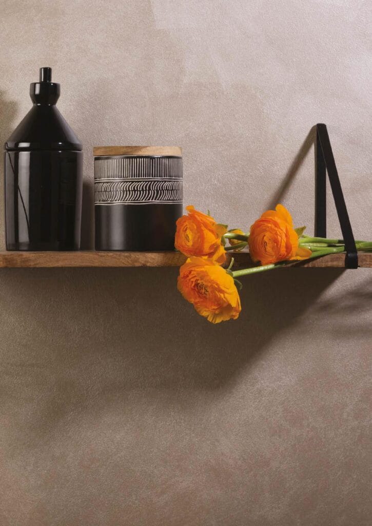 Perete cu finisaj decorativ mineral și raft cu obiecte de design, în showroom